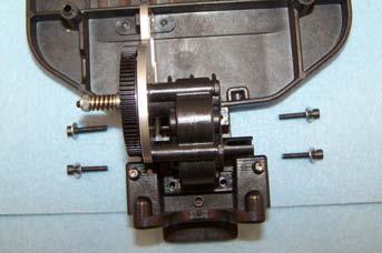 E9) Carefully place the four shims on the chassis over the transmission bolt holes.
