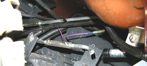2 Using a wire tie, secure the relay and fuse holder of the relay harness to a hole in the frame, above and forward of the battery, as shown in figure 2.