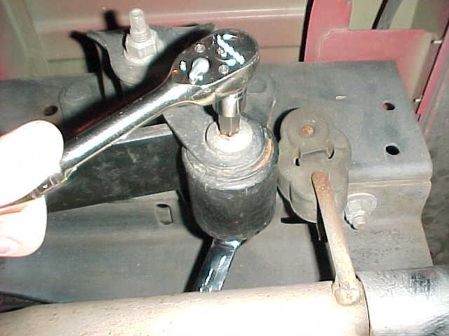 4) Use a 21mm socket or wrench to loosen and remove the nuts and plate that retain the