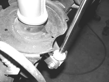 23. Locate the lower coil seat on the rear axle. Mark a 4 area on the coil seat directly behind the shock shaft. Disconnect the shocks from the lower mounts.