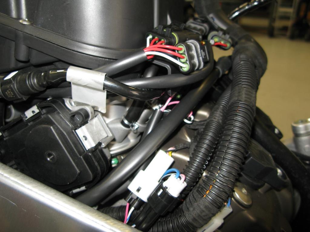 Locate the Gear Position Sensor connectors found between the left side frame spar and the left rear cylinder head.