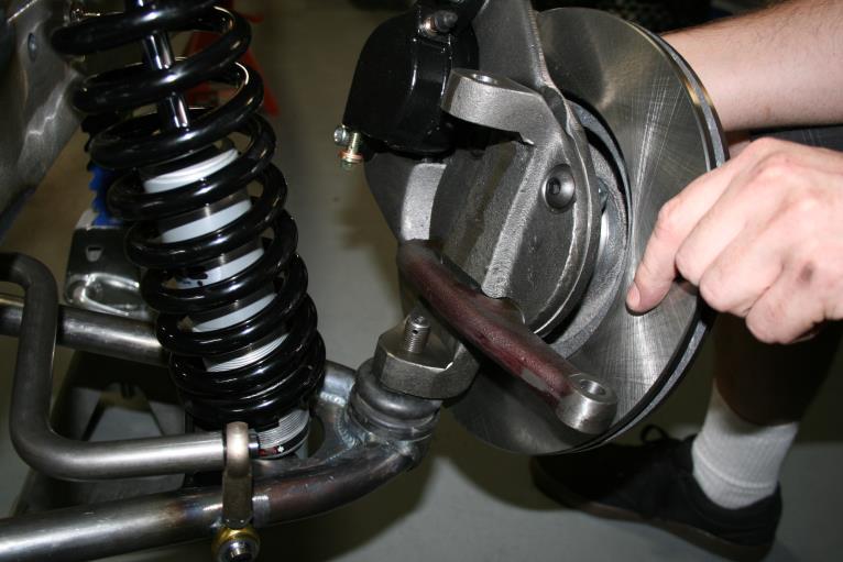 Installing the spindle assemblies: Place the spindle onto the lower ball joint with the steering arm facing forward with the large I/D tie rod end taper facing down.