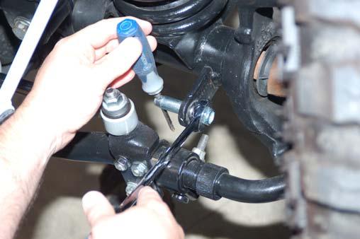 Remove the sway bar link from the bracket while holding the bracket in place.