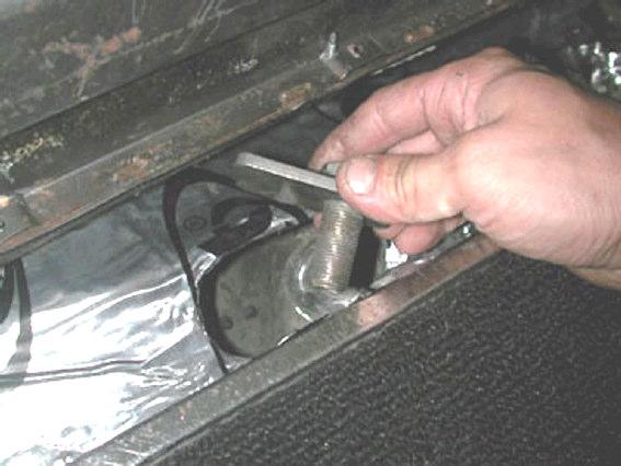 It is held in place by two 5/16 bolts with lock washers and flat washers. Two additional 7/16 holes must be drilled through the floor pan.