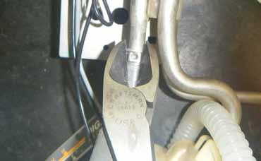 21. Using a pair of Oetiker pliers (or side cutting pliers), crimp the end of the clamp in the squared off section as shown to secure the