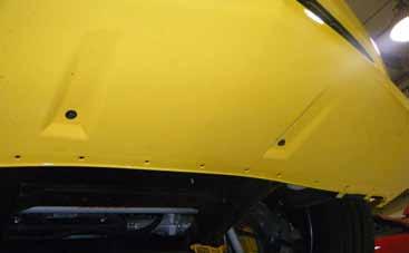 8. Place the chin spoiler support bracket under the middle of the vehicle in the position shown.