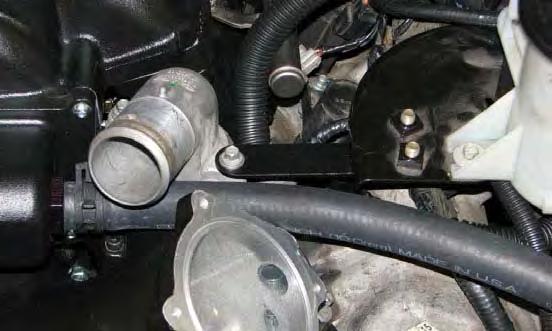 Install the power steering reservoir strap between the thermostat housing and the power steering reservoir bracket and secure it using the stock bolts.