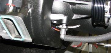 Lay the intercooler-to-reservoir tank hose in the engine bay, routed along the firewall behind the oil pressure sensor, and connect it to the intercooler reservoir inlet, securing the fitting with a