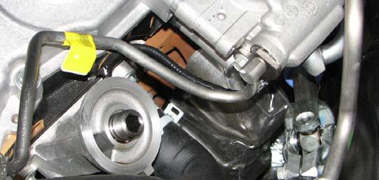 63. Use a 10mm socket to remove the bolt securing the power steering pressure line to the crossmember. 64a.