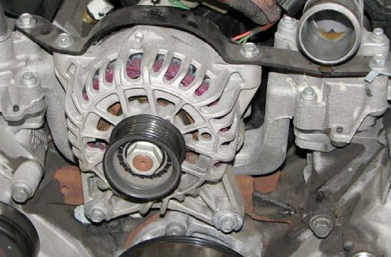 Support the alternator while using a 10mm socket to loosen the two bolts that support the alternator.