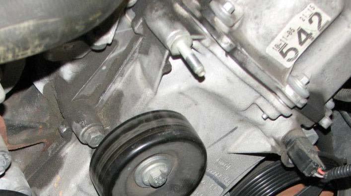 Use a 15mm wrench to remove the nut from the stud located at the top of the engine cover, on the driver side. 53.
