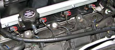77. Route the fuel crossover hose behind the manifold and around the fuel supply line as you install