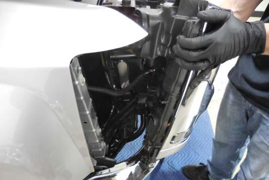 Lift up carefully on the headlight to separate it from the frame and disconnect the wiring harness plug (shown