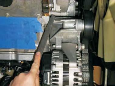 Using a file or die grinder, remove material from the alternator mounting bracket marked in
