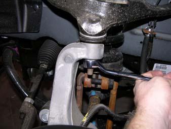 Pull down on the upper control arm to reinstall the ball joint and nut into the knuckle.