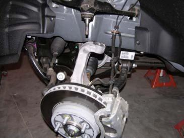 Remove the upper control arm ball joint nut with a 21mm wrench and separate the upper ball joint from