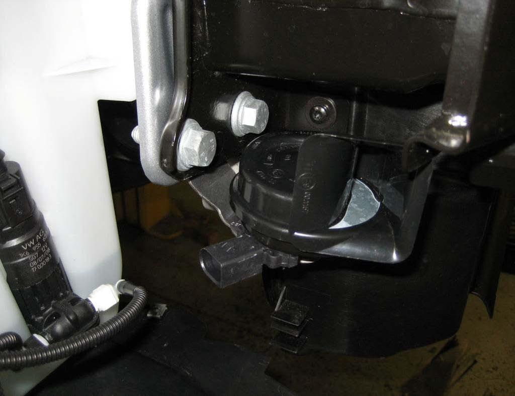 20. On the passenger side, remove the 12mm bolt that holds the horn bracket to the car and then using the right angled