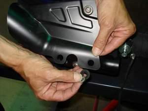 4) Release clamp at the front of the muffler box.