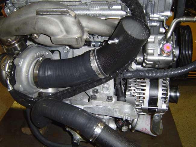 22. Once the intake is in place and tight remove the exhaust manifold heat shield and the bolt holding the compressor outlet tube onto the alternator bracket to clear room around the intake.