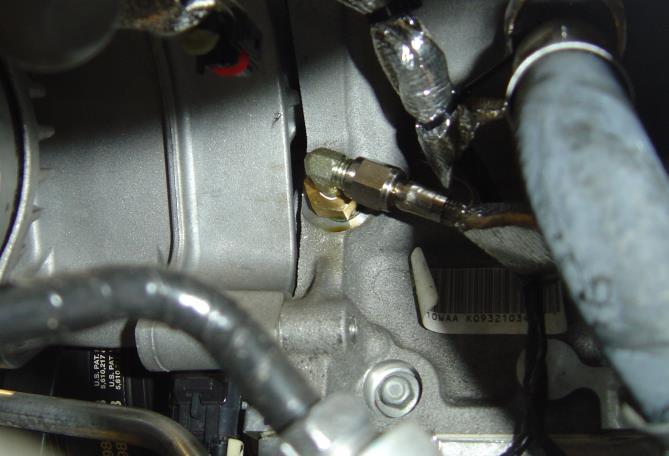 7. Install and tighten the -4 oil line (with heat shielding) to the fitting as shown, leaving the other end