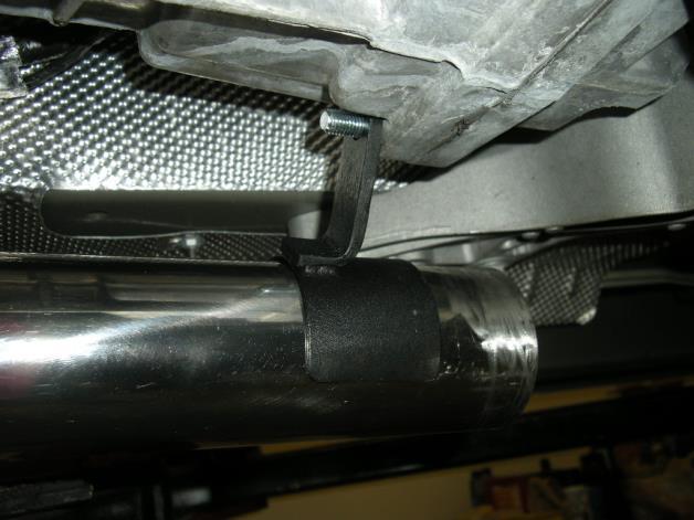 10. Install the supplied heat shield onto the turbine housing and secure with safety wire looped around the three metal hooks. 11. Remove the bolt in the rear passenger side of the transmission.