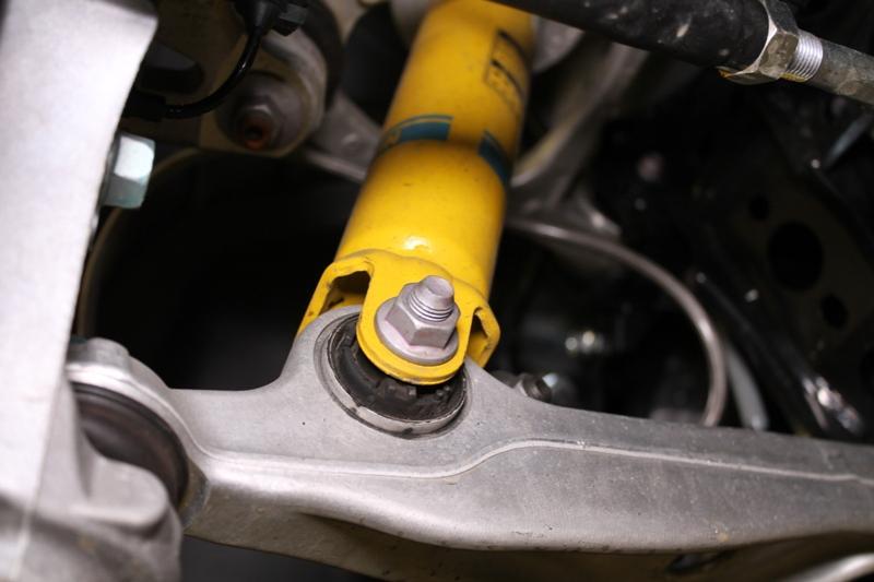 Using a 17mm socket and 17mm wrench, remove the bolt and nut securing the lower portion of the strut to the lower control