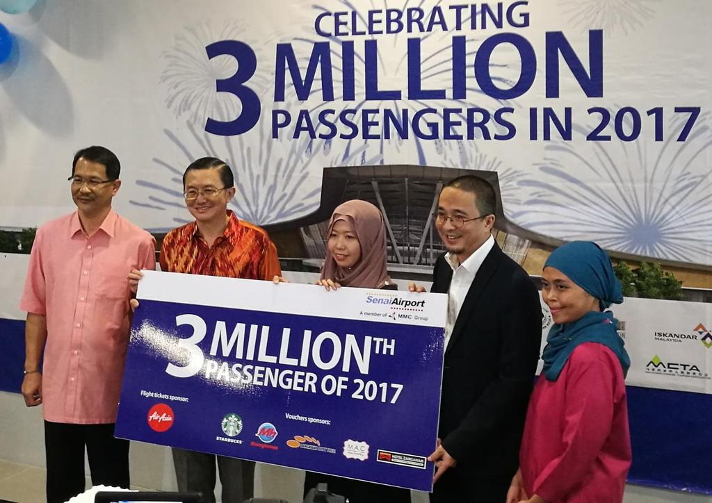 (From left) Abdul Malik Ismail, Datuk Tee Siew Kiong and Md Derick Basir welcome Umi Kalsom Roseli, Senai International Airport s three millionth passenger of 2017.