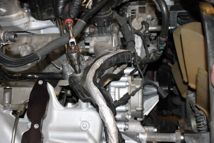 Using a 3/8in drive ratchet or breaker bar, remove factory serpentine belt by rotating