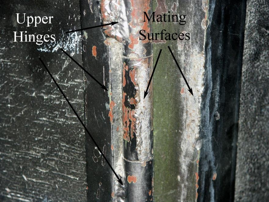 Closer image of broken hinge illustrating the separation and orientation of the fracture surfaces.