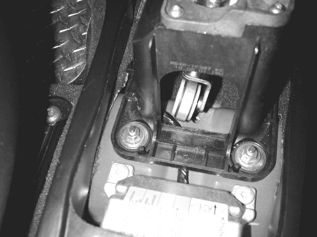 View 7 Shift Assist Top cover STEP 7: This is the most important step! Look under the shift lever towards the floor. There you should find a wire that runs under the shifter base (view 8).