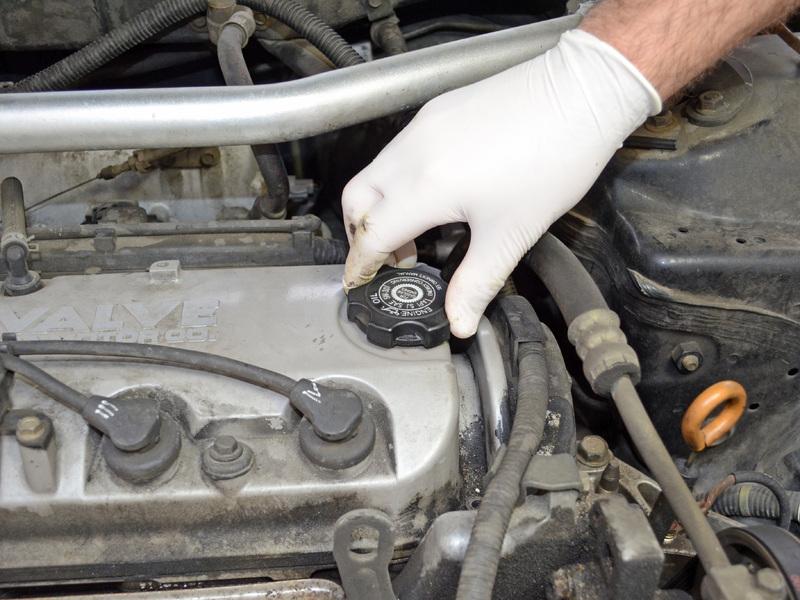 Step 12 Twist the oil filler cap counterclockwise, and remove it from the top of the engine.