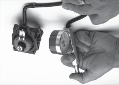 8. Pressure check carburetor. Attach pump with pressure gauge to fuel inlet fitting on carburetor (see Figure 33). With carburetor upside down (float up), raise float and lower to its normal position.