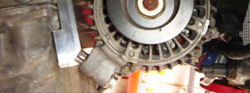 spacer onto the bolt and thread by hand into the upper left hole where the A/C compressor previously mounted.