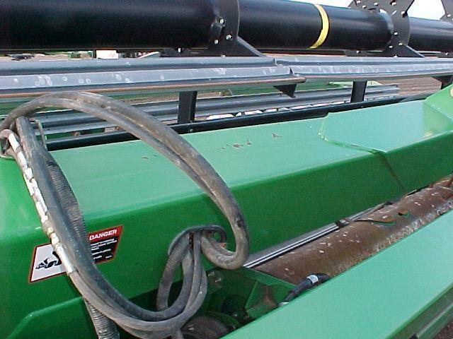Refer to Figure(s) 2.5 & 2.6 2.5 Pull taped hoses from right side opening through the left side opening. 2.6 Un-tape hydraulic hoses that were just pulled through left side opening. 2.7 Tape hydraulic hose (LAN169852) with red band to reel drive return hose that was just pulled through without a hose extension.