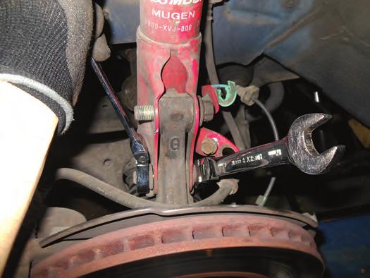 2. Unclip the wheel sensor harness from the strut. 3. Support the hub and remove the two lower strut bolts (fig. 7). fig. 7 4.