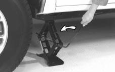 Make sure the cone-shaped end is toward the wheel. 9. Lower the vehicle by turning the jack handle counterclockwise.