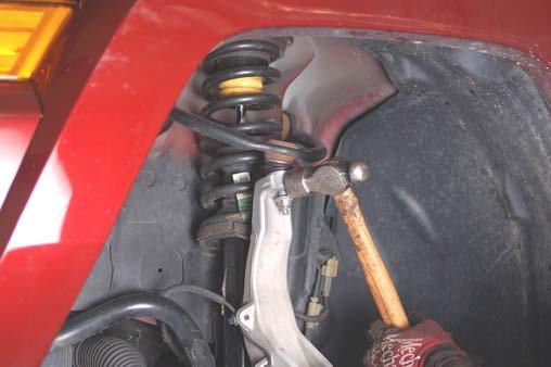 15. Loosen the upper ball joint nut as shown with a 18mm wrench.