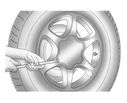 Vehicle Care 10-77 2. Remove the center cap by placing the chisel end of the wheel wrench in the slot on the wheel and gently prying the cap out. 3. Use the wheel wrench to loosen all the wheel nuts.