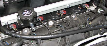 Route the fuel crossover hose behind the manifold and around the fuel supply line as you install the passenger side