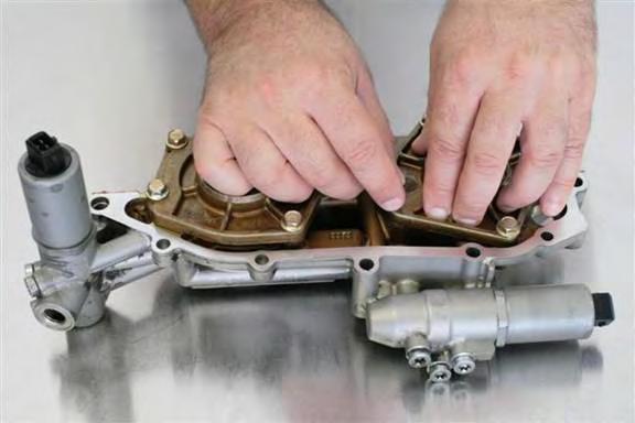 Install cylinder covers w/ pistons onto corresponding vanos cylinders. On exhaust side, align spring to fit properly into vanos cylinder spring groove and piston spring groove.