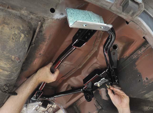 14. Position the cradle against the vehicle, aligning the cradle tabs with the factory shock mounting holes and the slotted