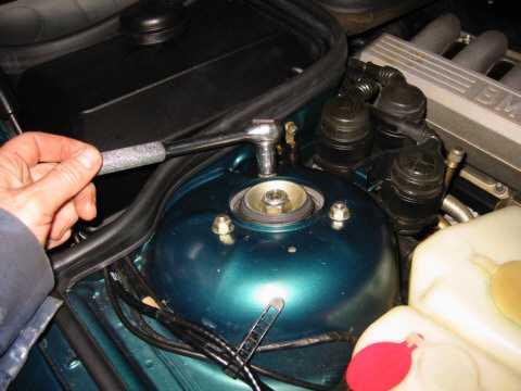 Loosen the 22 mm nut on the top of the shock absorber piston before removing the strut assembly from the car.
