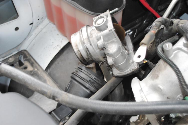 (Image 9) Step 3: Remove the wire connector and the four bolts that hold the forward most section of the cast intercooler piping