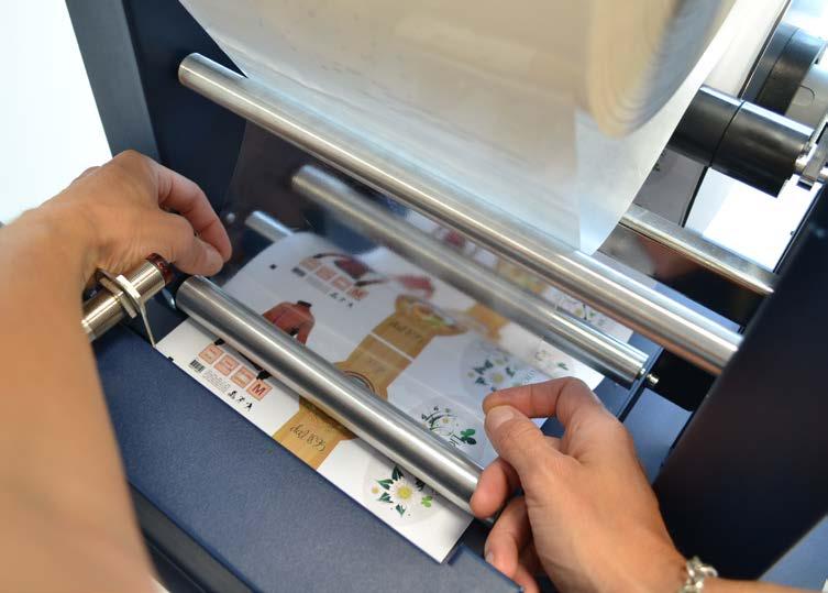 Hold the laminating film with both hands, pull it underneath the guide roller, center it, and adhere the laminating