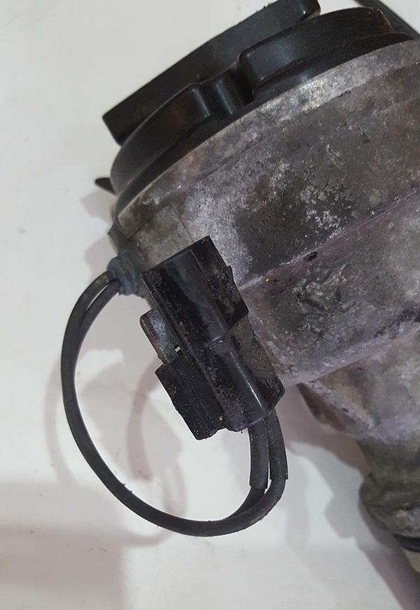 small two pin black plug mounted on the side of the distributor on a bracket.