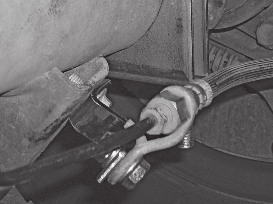 If it is then, bend the tab holding the brake line away from the axle housing (Fig. 14).
