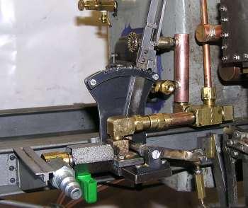 The support bracket is silver soldered to the elbow to the right of the compressed air valve. The bracket screws into the reverse lever mounting bracket.