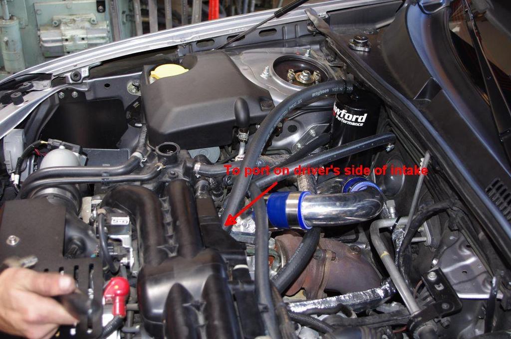 22. Connect the 29 long, ½ wide hose from the left head (US drivers side) to the T fitting. Zip tie both ends to secure. In the photo, the hose resting on top of the manifold for reference.