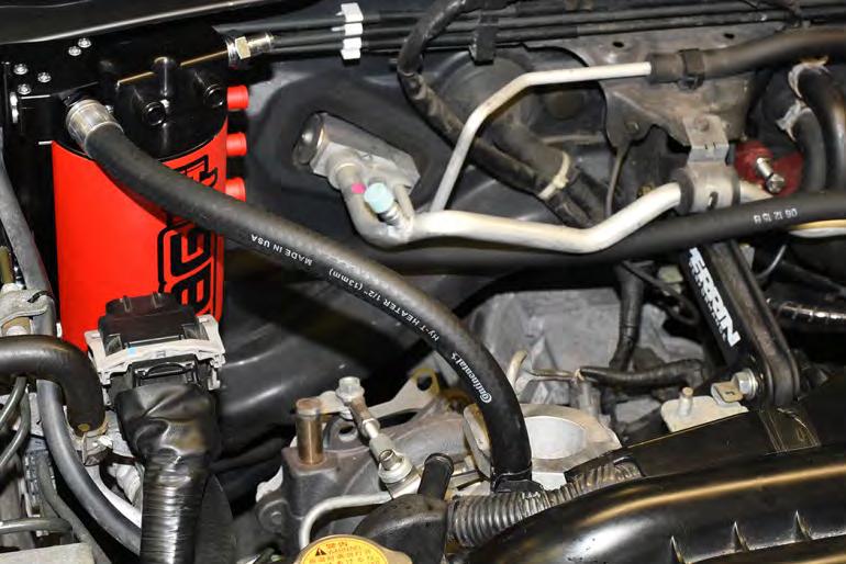 The hose should be routed under the main harness and lead to the coolant expansion