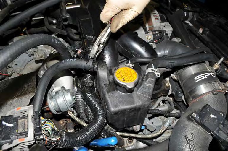 Remove the hose clamping pliers from the turbocharger coolant drain line. 32. Locate the AOS oil drain line.